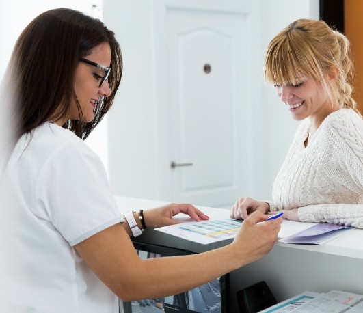 Dental team member showing paperwork to a patient