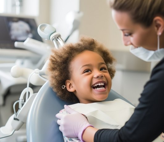 Young child laughing in dental chair