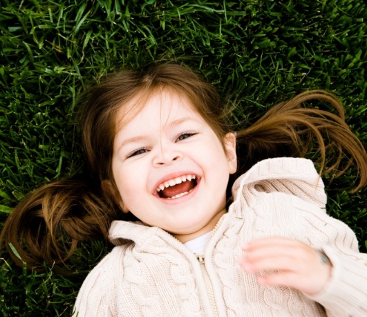 Laughing girl laying down on grass