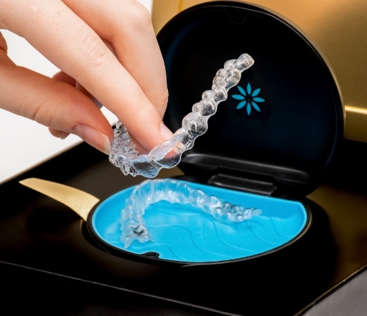 Hand placing an Invisalign aligner back into its storage case