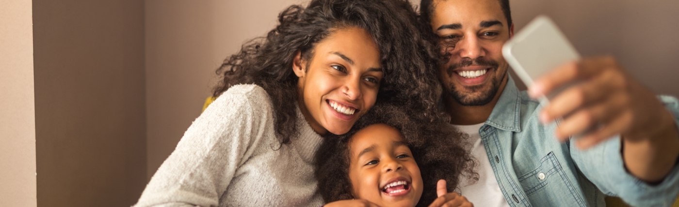 Smiling family of three taking a selfie together