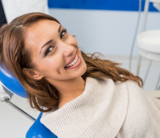 Smiling woman leaning back in dental chair