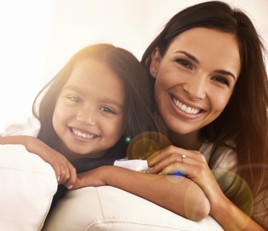 Mother and daughter smiling and hugging