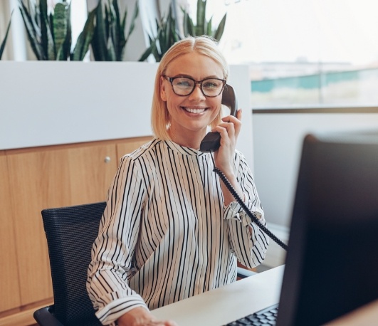 Smiling dental team member answering the phone