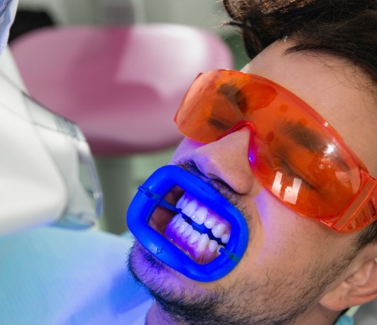 Man in dental chair getting professional teeth whitening