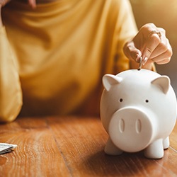 Person putting money in a piggy bank