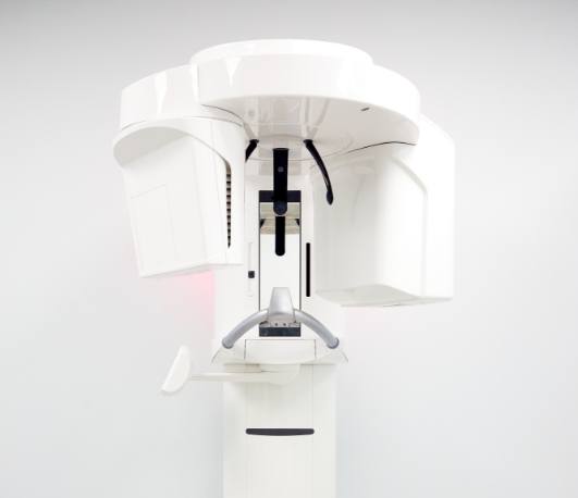 3 D cone beam scanner standing against white wall