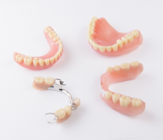 Two full dentures and two partials against white background