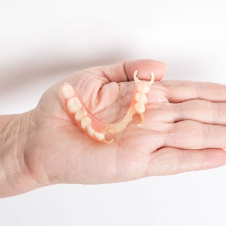 Hand holding a partial denture