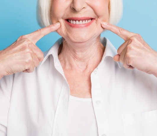 Senior woman pointing to her smile