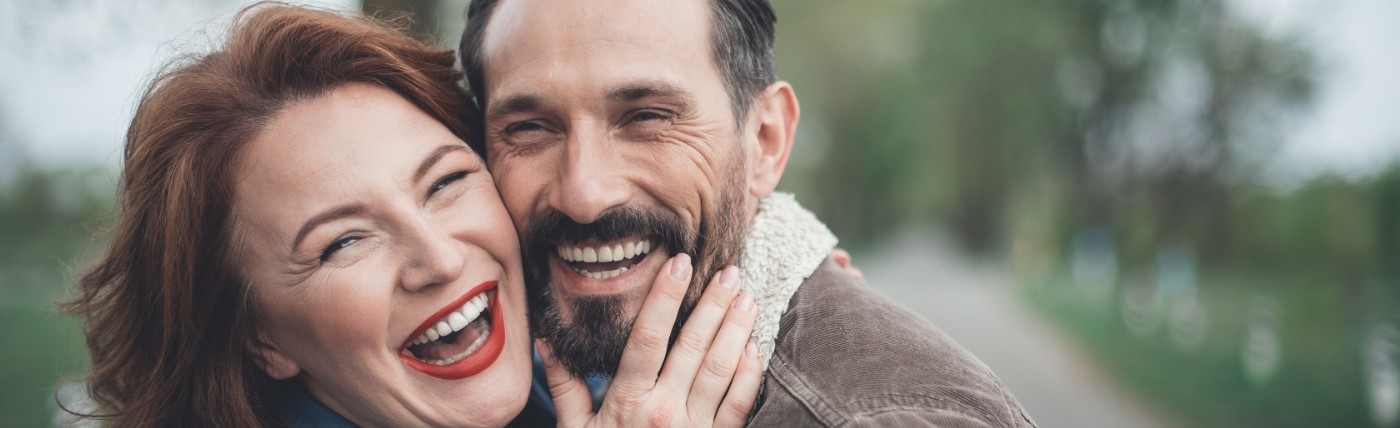 Older man and woman laughing together outdoors