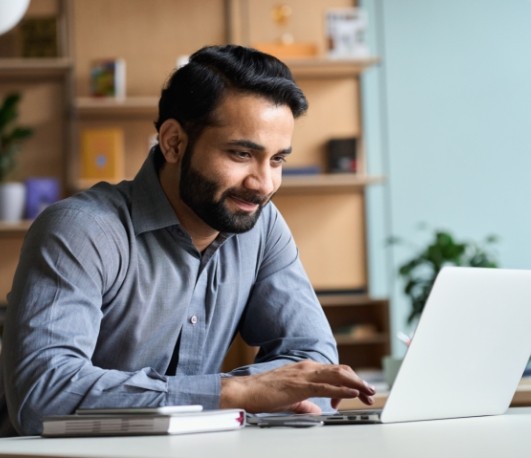 Man sitting at desk and using laptop