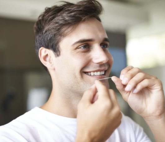 Man flossing his teeth