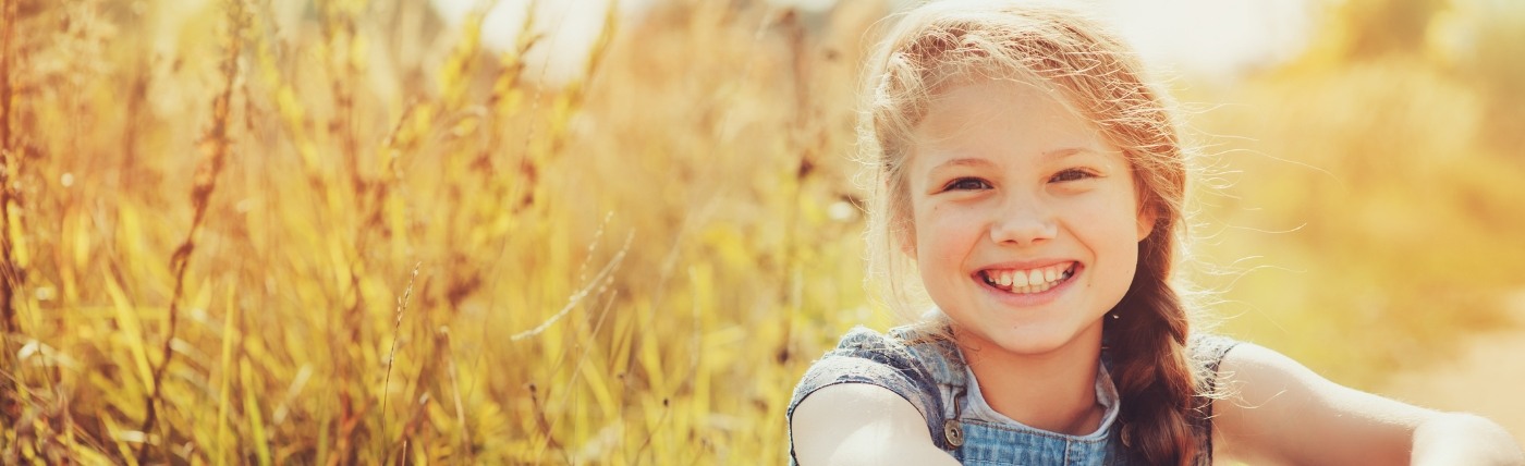 Young girl smiling outdoors after treatment with HealthyStart in Waco