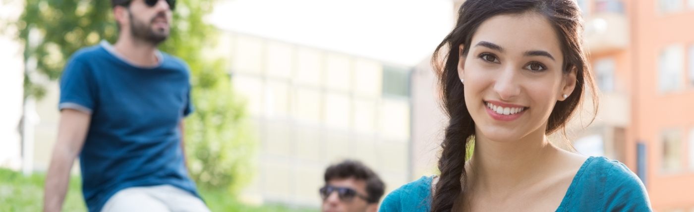 Young woman smiling outdoors after orthodontics in Waco