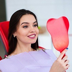 woman checking smile in red mirror