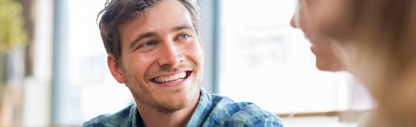 Man in blue plaid shirt smiling after restorative dentistry in Waco