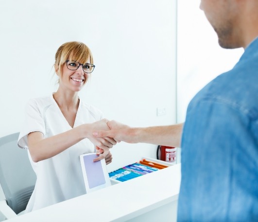 Man shaking hands with dental team member