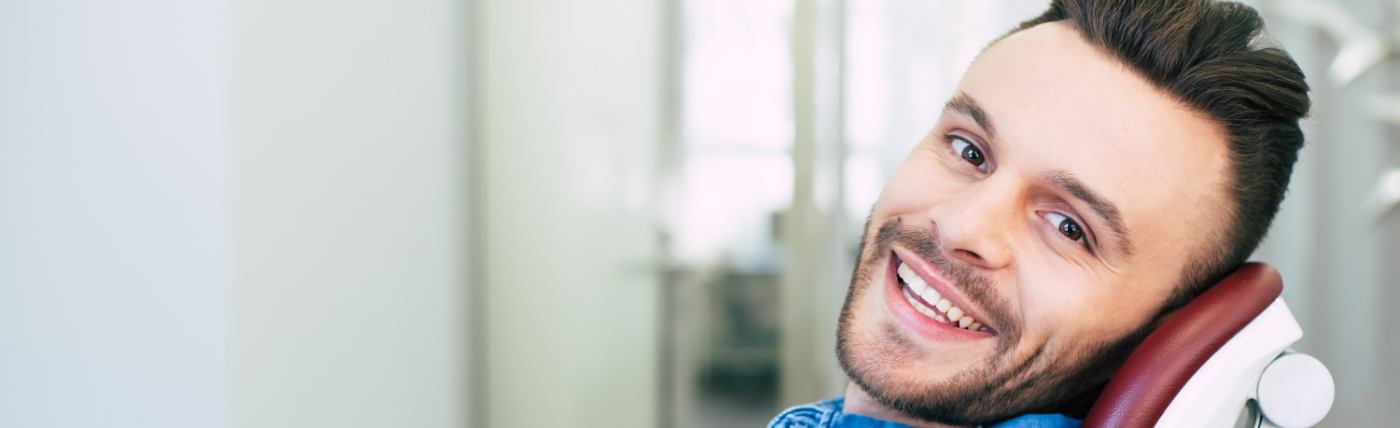 Smiling man in dental chair after scaling and root planing in Waco