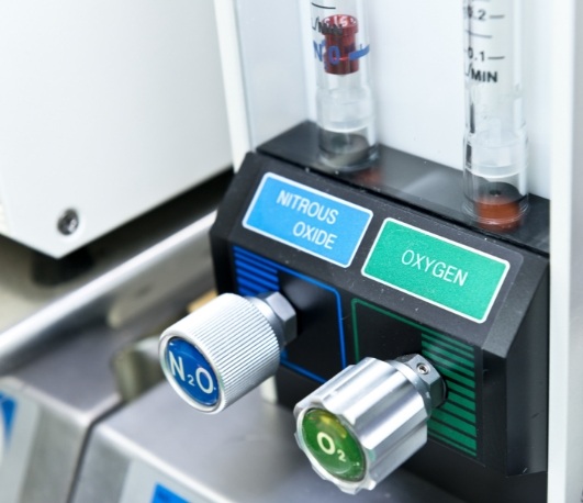 Buttons on machine in dental office with one reading nitrous oxide and one reading oxygen