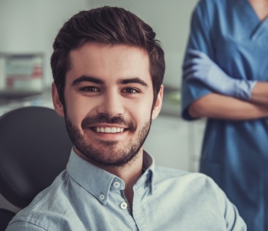 Smiling young man sitting in dental chair