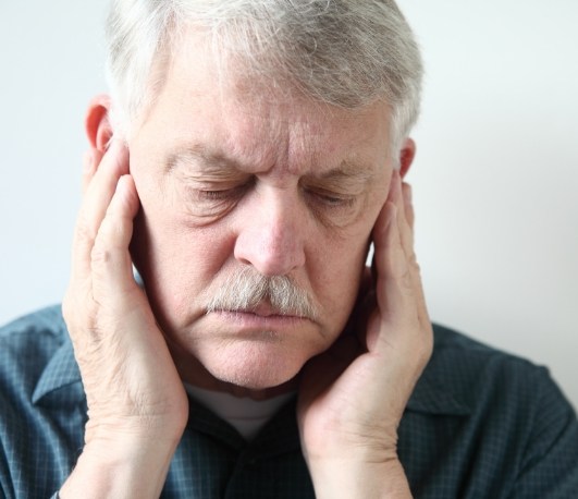 Older man holding his temples in pain