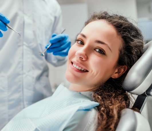 Smiling woman leaning back in dental chair