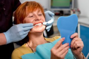 An older women examining her new smile.