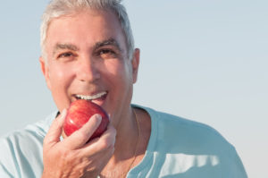 older man preparing to eat apple