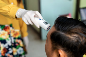 A dentist in Waco completes a temperature screening.