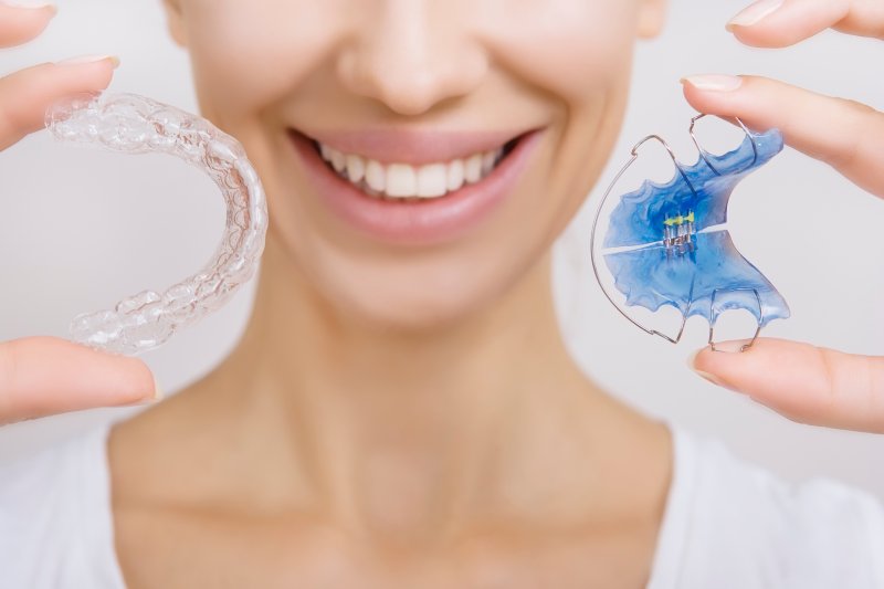 person smiling and holding retainer in Waco