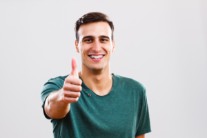 a patient with braces giving a thumbs up