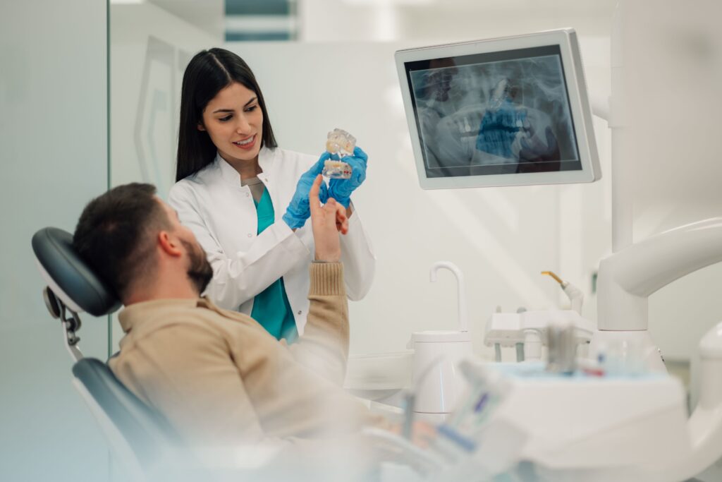 Dentist showing patient sample implant and x-rays
