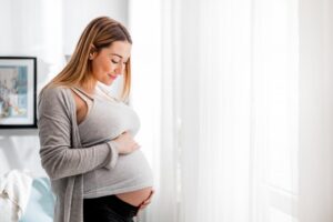 s: pregnant woman smiling at her belly